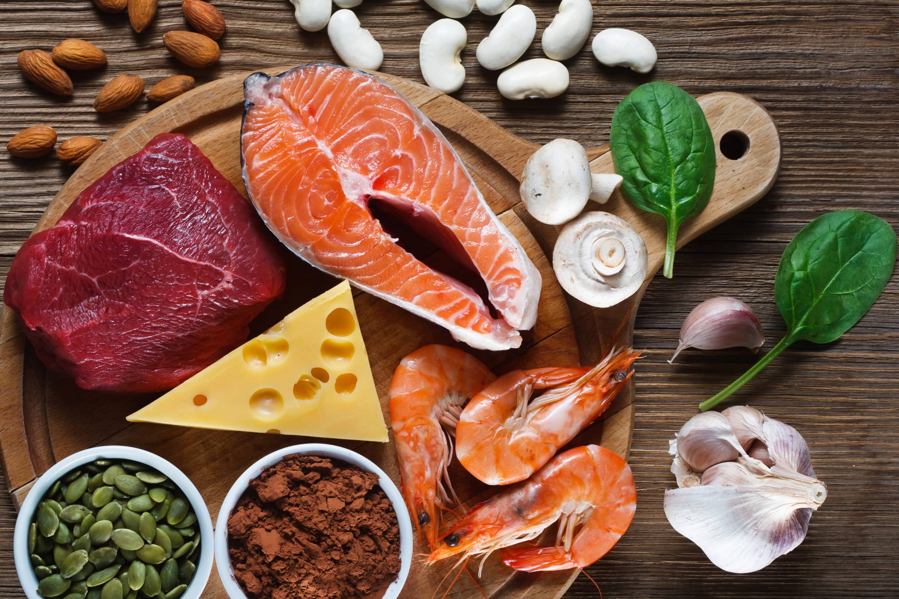 Foods High in Zinc including salmon, seafood-shrimps, beef, yellow cheese, spinach, mushrooms, cocoa, pumpkin seeds, garlic, bean and almonds. 